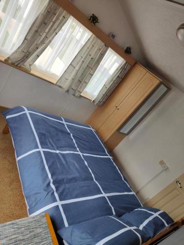 a bed in a room with two windows at H9 Fairway Holiday Park Sandown in Sandown