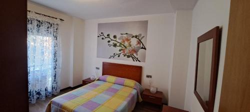 a bedroom with a bed and a painting on the wall at Constitución 80 in Úbeda