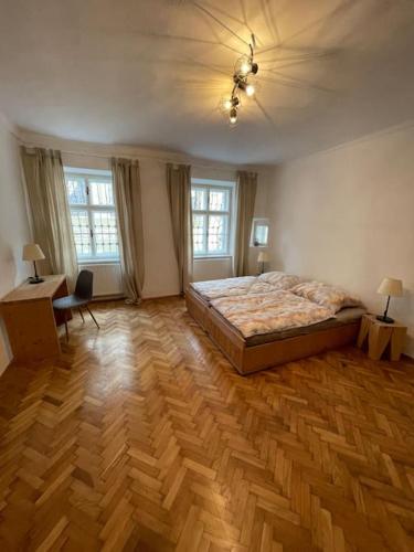 a bedroom with a bed and a wooden floor at Altstadt Apartment in Steyr