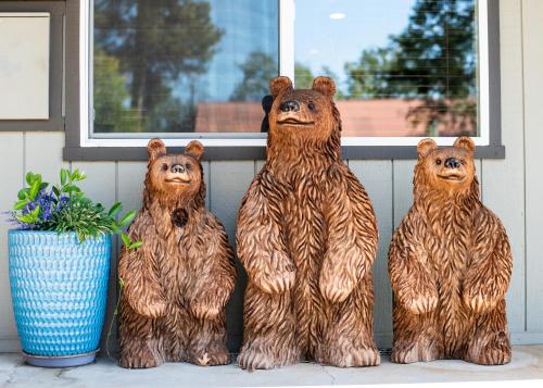 three bear statues sitting in front of a window at Yosemite Westgate Lodge in Groveland