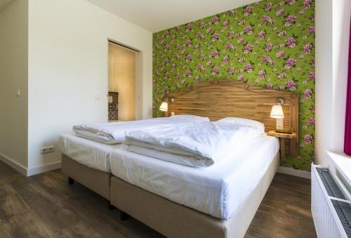 a bedroom with a large bed with a floral wall at Herberg de Geulhemermolen in Berg en Terblijt