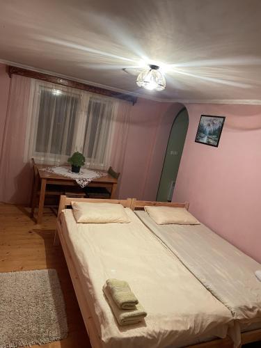 a bedroom with two beds and a table at House Menchul in Mala Uhol'ka