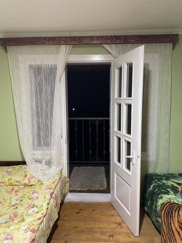 a bedroom with a bed and an open door at House Menchul in Mala Uhol'ka