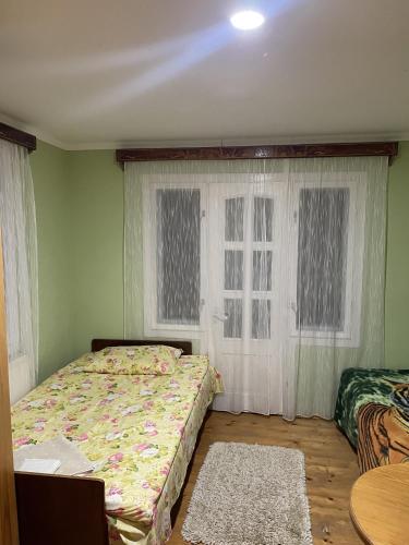 a bedroom with a bed and a window at House Menchul in Mala Uhol'ka
