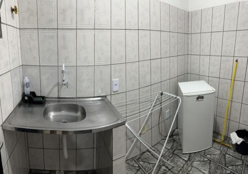 ein Bad mit einem Waschbecken in einer gefliesten Wand in der Unterkunft Residencial Margarida APART 4 in Presidente Figueiredo