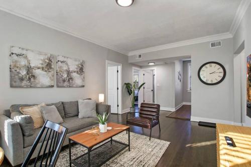 a living room with a couch and a clock on the wall at Comfortable 2BR Chicago Apt - Sunnyside 2F in Chicago