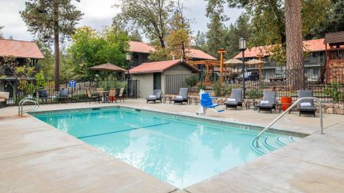 uma piscina num resort com cadeiras em Yosemite Westgate Lodge em Groveland