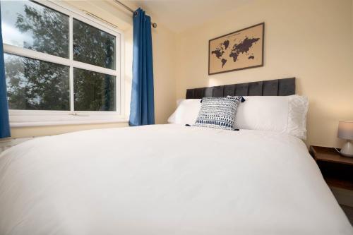 a bedroom with a white bed and a window at Stunning 3 bed with parking & garden in Market Rasen