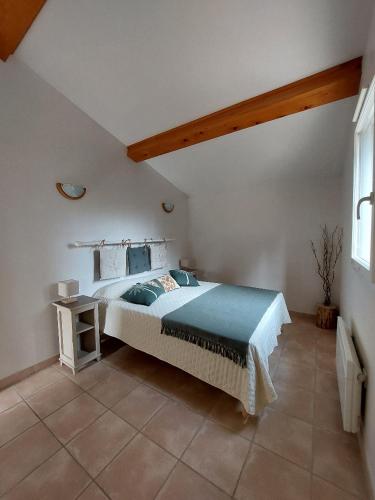 une chambre avec un grand lit et une table dans l'établissement En Provence, Chez Stéphanie et Marcel, à Saint-Rémy-de-Provence