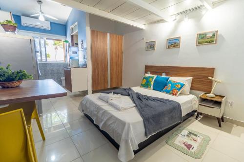 ein Schlafzimmer mit einem Bett und einem Tisch darin in der Unterkunft Mini paraíso do Francês/ Pé na areia in Marechal Deodoro
