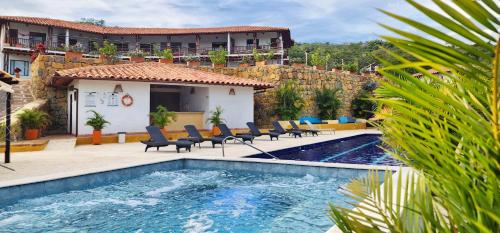 una piscina con sillas y un edificio de fondo en Hotel AMANEE, en Barichara