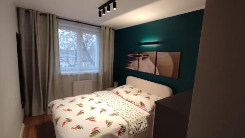 sypialnia z łóżkiem i zieloną ścianą w obiekcie Apartament typu studio we Włocławku