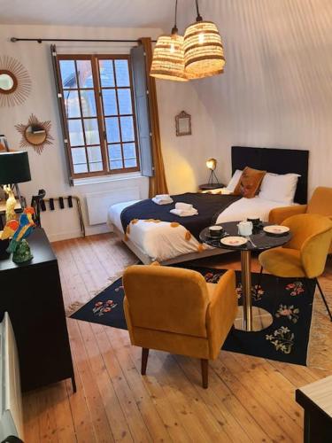 un salon avec un lit, une table et des chaises dans l'établissement Studio Basilique St Martin, à Tours