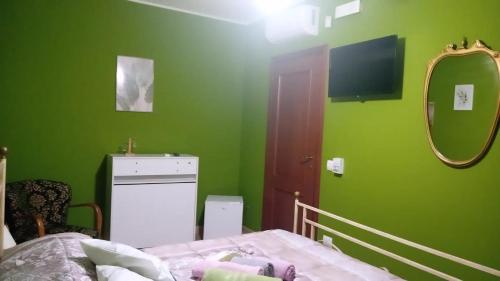 a bedroom with green walls and a bed and a mirror at Villa Levante in Barletta