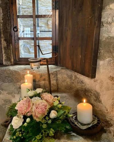 a bouquet of roses and candles in a sink at B&B La Tour de Villa in Aosta