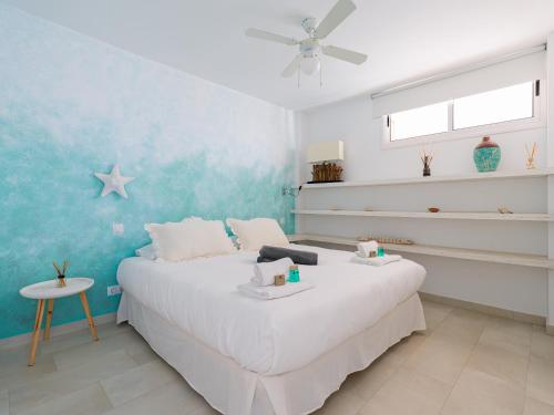 莫甘的住宿－Haiti 306 vista al mar，卧室配有白色的床和蓝色的墙壁