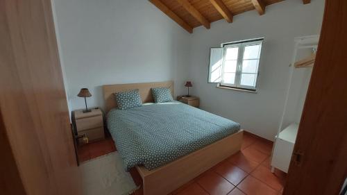 a bedroom with a bed and a window at Monte Gaia in Cavaleiro