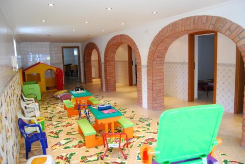 a room with tables and chairs in a play room at D. Afonso Hotel & SPA in Monte Real