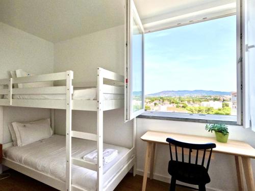 a room with bunk beds and a desk and a window at Peaceful & panoramic views apartment, Cascais in Cascais