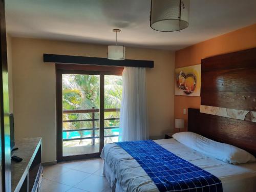 ein Schlafzimmer mit einem Bett und einem großen Fenster in der Unterkunft Apartamento 320 Praia Bonita Resort in Nísia Floresta