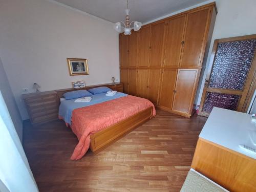 a bedroom with a bed and a wooden cabinet at B&B Corallo in Sassari