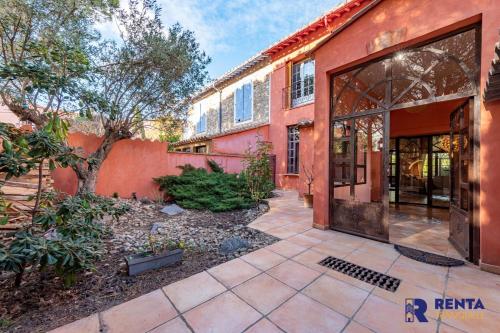 an exterior view of a red building with a courtyard at The Villa Jardin de Balata in Saleilles