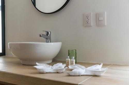 a bathroom with a sink and a counter with towels at Casa Arena mia, Chicxulub by Casago in Chicxulub