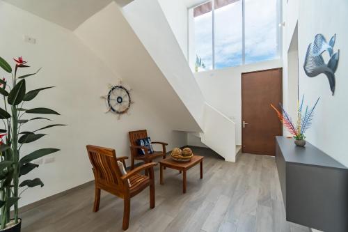 a living room with two chairs and a table at Casa Arena mia, Chicxulub by Casago in Chicxulub