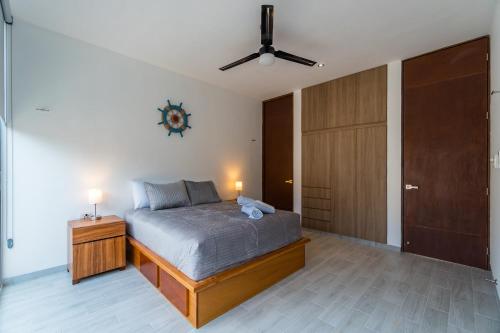 a bedroom with a bed and a ceiling fan at Casa Arena mia, Chicxulub by Casago in Chicxulub
