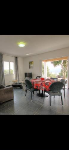 - un salon avec une table et des chaises rouges dans l'établissement Villa les oliviers, à Olmeto