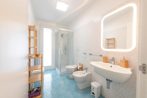 a white bathroom with a sink and a toilet at Villette Orsa Maggiore in Pozzallo