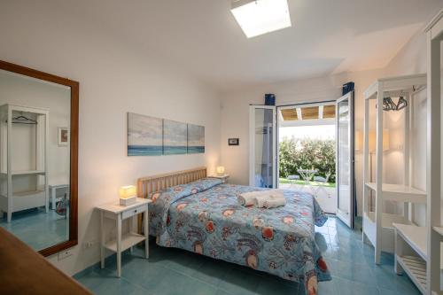 a bedroom with a bed and a mirror and a window at Villette Orsa Maggiore in Pozzallo