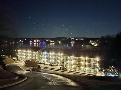 a building lit up at night with a body of water at B Lakefront! Remodeled, Boat Slip, Patio Views, Pool, Boat Ramp, WIFI in Osage Beach