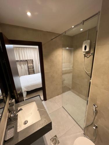 a bathroom with a shower and a sink and a toilet at Touch Residence in Al Ḩamīdīyah