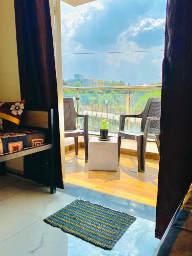浦那的住宿－The Peacewood's Homes - Pune's Comfort - Hostel & PG，客房设有带桌椅的阳台。