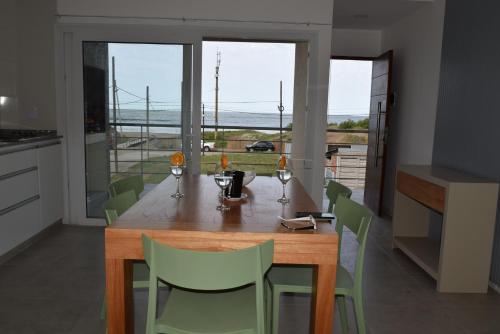 a kitchen with a wooden table and green chairs at Condo Costa Azul in Costa Azul