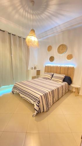 a bedroom with a bed and a chandelier at Full Appartement Ville Haute wifi in Kenitra