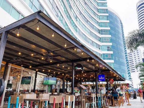a restaurant with chairs and tables and a building at Depa de lujo con piscina y jacuzzi in Guayaquil