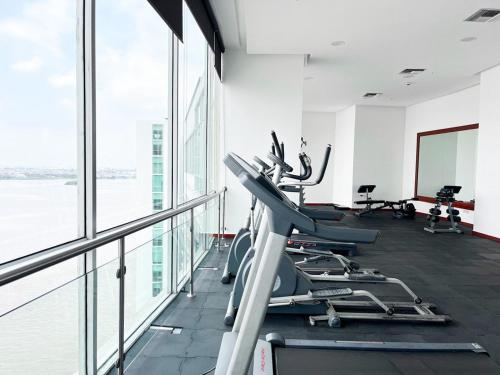 a gym with treadmills and elliptical machines at Depa de lujo con piscina y jacuzzi in Guayaquil