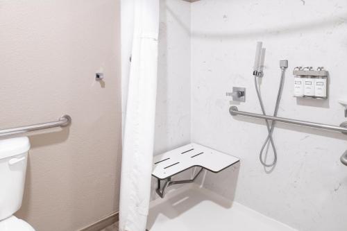 a white bathroom with a toilet and a shower at Yosemite Westgate Lodge in Groveland