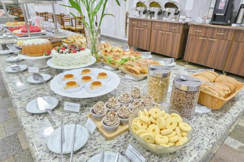a buffet of pastries and desserts on a table at Hotel Nacional Inn Limeira in Limeira