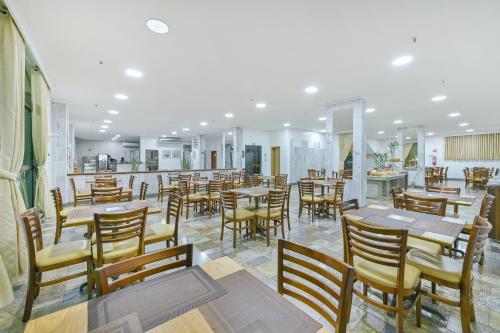 a restaurant with wooden tables and chairs and a bar at Hotel Nacional Inn Limeira in Limeira