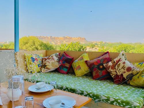a couch with colorful pillows sitting on a table at Jasmer Haveli in Jaisalmer