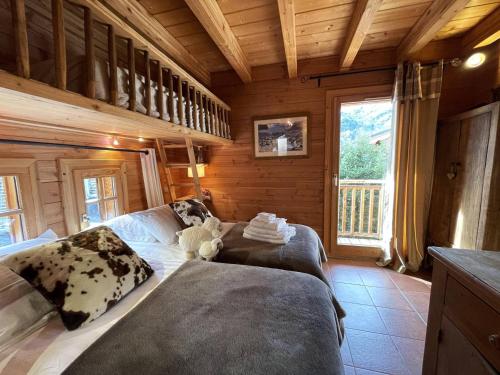 a bedroom with a bed in a wooden cabin at Chalet de charme 8 pers avec parking, cheminée et terrasse - Saint-Martin-de-Belleville - FR-1-452-35 in Saint-Martin-de-Belleville