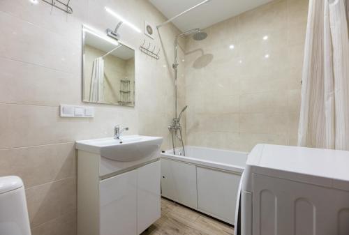 a white bathroom with a sink and a bath tub at 0301 ComfortApartments JK Schastliviy Zhuliany Airport in Kyiv