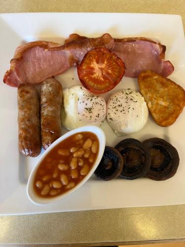 un plato de desayuno con judías de tocino y huevos en The Swallow Hotel, en Bridlington