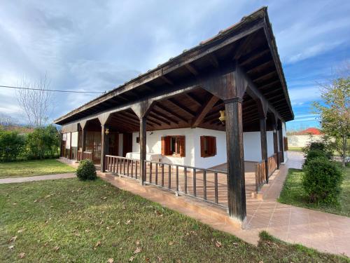 a large building with a wooden roof on a field at Traditional County House close to Trikala 