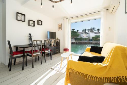 ein Wohnzimmer mit einem Sofa und einem Tisch in der Unterkunft L'Échappée Marine - Classé 2 étoiles parking privé in Cap d'Agde