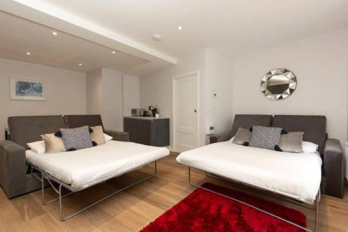 ロンドンにあるPremier Central London North Apartmentの赤い敷物が敷かれた部屋のベッド2台