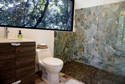 baño con aseo y pared de mosaico en LALDEA Nirvana Eco Villa in Cerritos, en Pereira